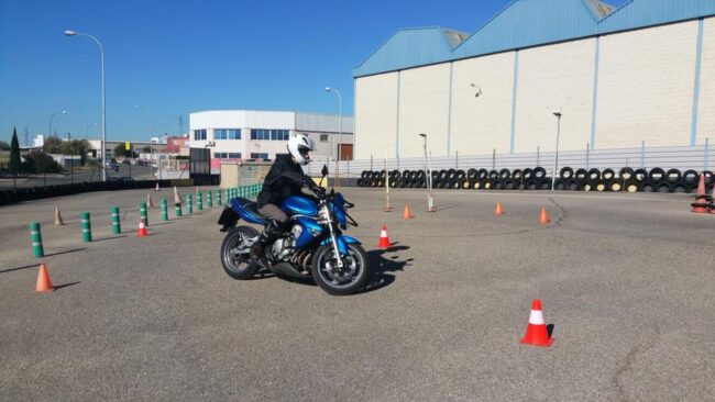 Alumno de la autoescuela MotoCircuito realizando prácticas de circulación en moto por las calles de Móstoles, seguido por el coche del profesor.