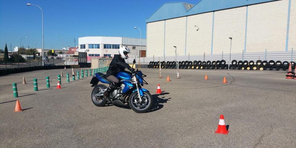 Alumno de la autoescuela MotoCircuito realizando prácticas de circulación en moto por las calles de Móstoles, seguido por el coche del profesor.