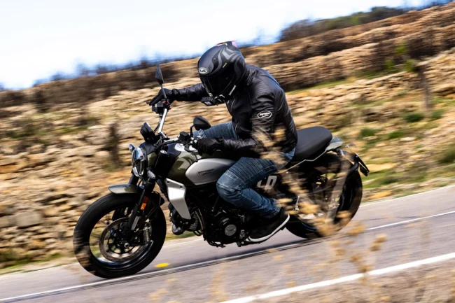 Alumna de la autoescuela MotoCircuito apoyando correctamente un solo pie en el suelo sobre una moto de prácticas del carnet A2 en el circuito privado de Móstoles.