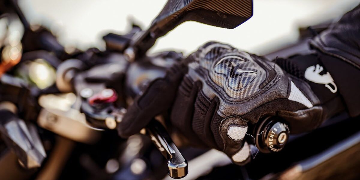 Detalle de la mano izquierda de un alumno de la autoescuela MotoCircuito accionando la maneta del embrague de una motocicleta de marchas en el circuito de Móstoles.