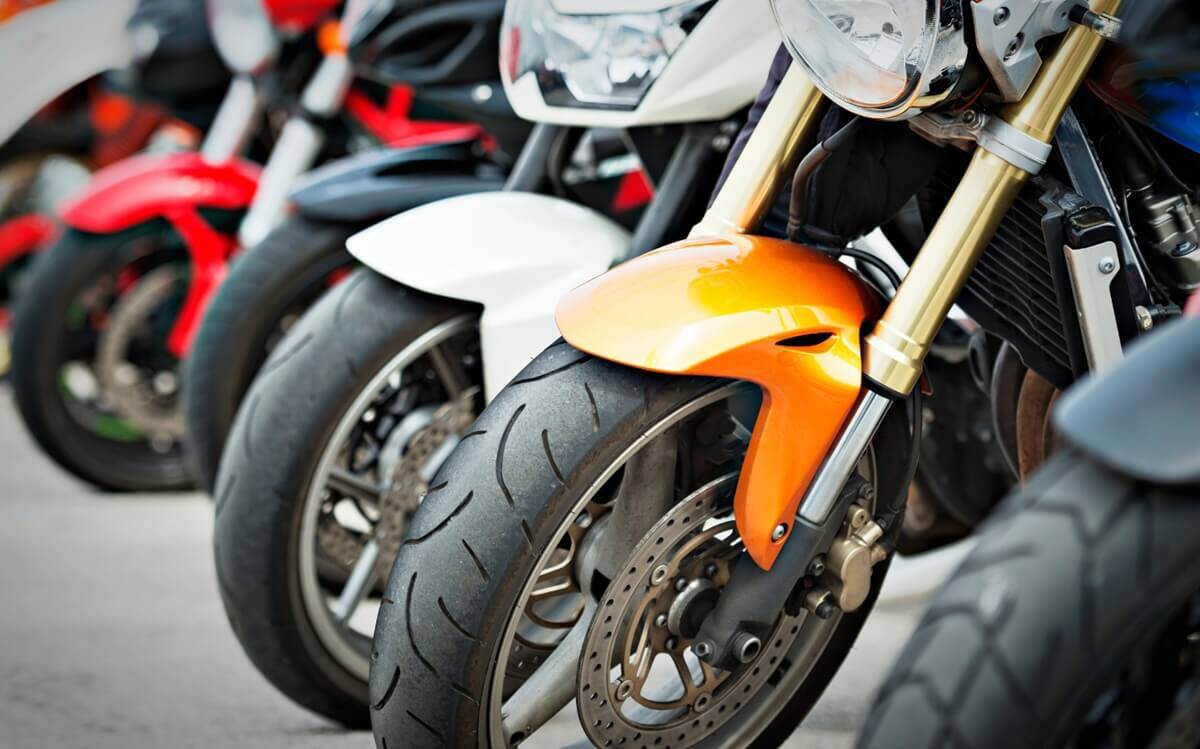 Flota de motocicletas de diferentes cilindradas de la autoescuela MotoCircuito aparcadas en el circuito privado de Móstoles, listas para los carnets AM, A1, A2 y A.