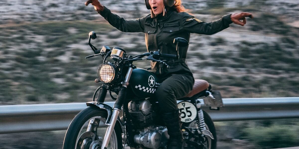 Alumna motera equipada y sonriente sobre una motocicleta de prácticas en el circuito privado de la autoescuela MotoCircuito en Móstoles.