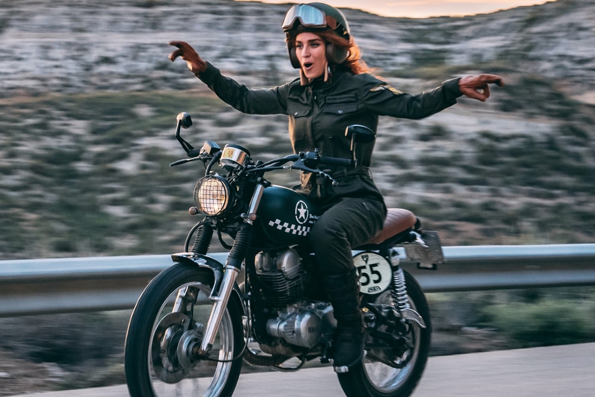 Alumna motera equipada y sonriente sobre una motocicleta de prácticas en el circuito privado de la autoescuela MotoCircuito en Móstoles.