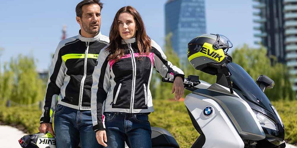 Detalle de un alumno de la autoescuela MotoCircuito ajustándose unos guantes de moto con protecciones y vistiendo una chaqueta homologada, preparándose para el examen práctico en Móstoles.