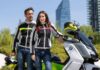 Detalle de un alumno de la autoescuela MotoCircuito ajustándose unos guantes de moto con protecciones y vistiendo una chaqueta homologada, preparándose para el examen práctico en Móstoles.