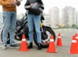 Un alumno feliz chocando la mano con su profesor de la autoescuela MotoCircuito en Móstoles tras aprobar su carnet de moto A2 a la primera, ahorrando dinero en tasas.