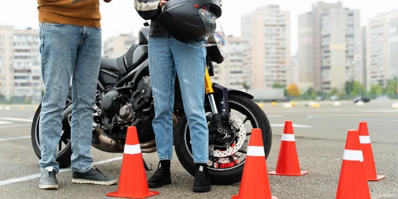 Un alumno feliz chocando la mano con su profesor de la autoescuela MotoCircuito en Móstoles tras aprobar su carnet de moto A2 a la primera, ahorrando dinero en tasas.