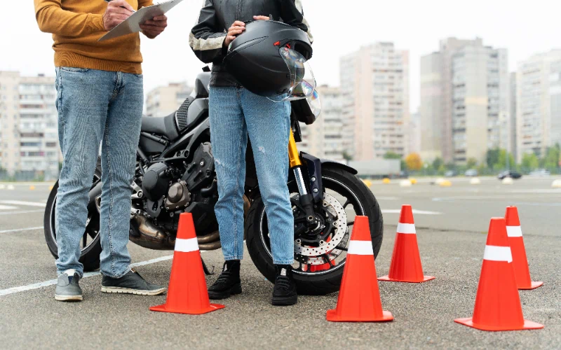 Un alumno feliz chocando la mano con su profesor de la autoescuela MotoCircuito en Móstoles tras aprobar su carnet de moto A2 a la primera, ahorrando dinero en tasas.