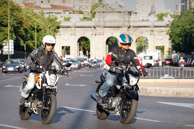 Motorista esperando correctamente en la zona de 'Avanzamotos' de un semáforo en Madrid, aplicando la técnica aprendida en la autoescuela MotoCircuito para circular en tráfico urbano.