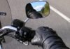 Detalle de la bota de un motorista accionando la palanca de cambios hacia arriba y la mano apretando el embrague, practicando la técnica en el circuito de la autoescuela MotoCircuito.
