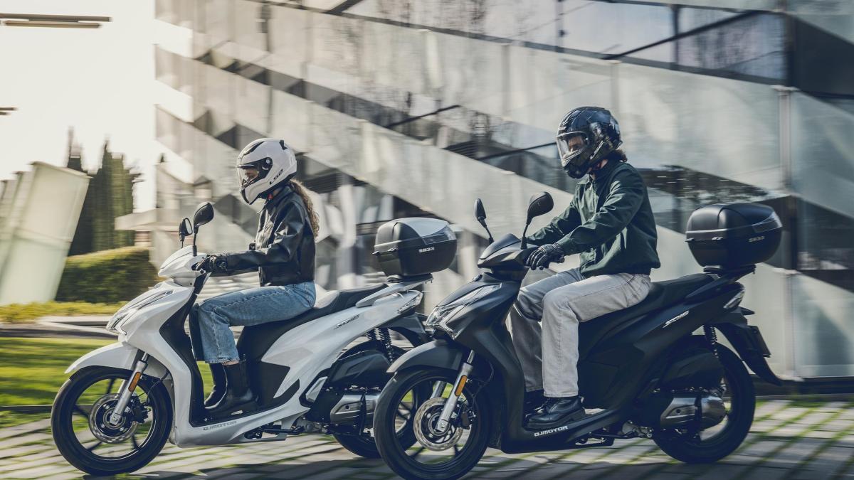 curso-obligatorio-125cc-carnet-b-vs-carnet-a2-madrid Comparativa entre un pequeño scooter de 125cc y una motocicleta tipo Naked apta para el carnet A2, aparcadas en las instalaciones de la autoescuela MotoCircuito en Móstoles.
