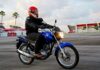 Rueda delantera de una motocicleta frenando justo antes de la línea blanca de detención en el circuito de pruebas, evitando así una falta eliminatoria en el examen de la DGT.