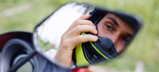Detalle de un casco de motorista equipado con el sistema de intercomunicación homologado, preparado para recibir las instrucciones del examinador de la DGT durante la prueba de calle.