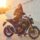 Una alumna sonriente de la autoescuela MotoCircuito equipada con casco y chaqueta, sentada con seguridad sobre una motocicleta de prácticas en el circuito de Móstoles.
