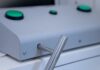 Detalle de las manos de un futuro motorista realizando la prueba de coordinación en la máquina de palancas durante el test psicotécnico para el carnet de moto.