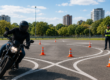 Alumno de la autoescuela MotoCircuito superando con éxito la prueba de las franjas metálicas (chapas) y los jalones en el circuito lento de Móstoles, manteniendo la mirada al frente.