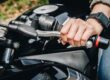 Detalle de las manos de un alumno de MotoCircuito operando con precisión la maneta de embrague y el acelerador para evitar calar la motocicleta durante una práctica en Móstoles.