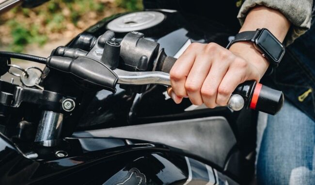Detalle de las manos de un alumno de MotoCircuito operando con precisión la maneta de embrague y el acelerador para evitar calar la motocicleta durante una práctica en Móstoles.