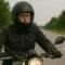 Motorista ajustándose las gafas de vista a través de la visera abierta de un casco integral antes de iniciar una práctica en el circuito de MotoCircuito en Móstoles.