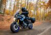 Alumno sonriente de MotoCircuito sosteniendo su carnet provisional de moto recién aprobado frente a las pistas de Móstoles, destacando la rapidez del proceso.