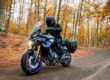 Alumno sonriente de MotoCircuito sosteniendo su carnet provisional de moto recién aprobado frente a las pistas de Móstoles, destacando la rapidez del proceso.