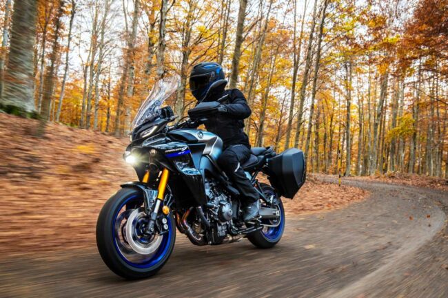 Alumno sonriente de MotoCircuito sosteniendo su carnet provisional de moto recién aprobado frente a las pistas de Móstoles, destacando la rapidez del proceso.
