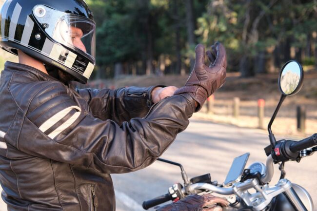 Detalle del equipamiento obligatorio para motoristas, mostrando botas específicas, pantalones con protecciones y guantes homologados en el circuito de la autoescuela MotoCircuito.