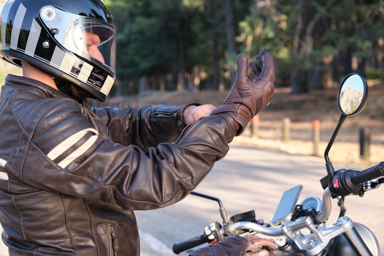 Detalle del equipamiento obligatorio para motoristas, mostrando botas específicas, pantalones con protecciones y guantes homologados en el circuito de la autoescuela MotoCircuito.