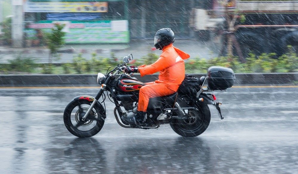Motocicleta de la autoescuela MotoCircuito realizando prácticas en el circuito mojado de Móstoles bajo la lluvia, demostrando el agarre y la seguridad del asfalto.