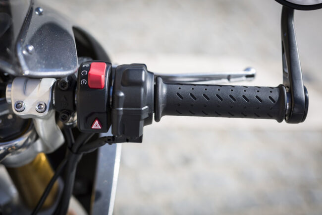 Detalle de la rueda delantera y la horquilla de una motocicleta realizando una frenada de emergencia controlada antes de la línea blanca en el circuito rápido de MotoCircuito.