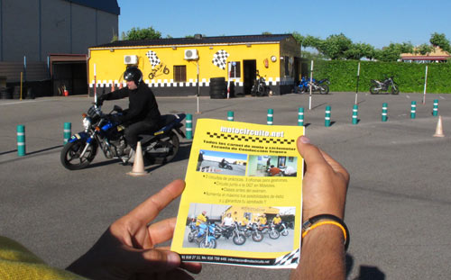 Motorista de la autoescuela MotoCircuito realizando un giro cerrado de 180 grados en el circuito rápido de Móstoles, aplicando la técnica de la mirada y el freno trasero.