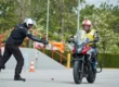 Alumno de la autoescuela MotoCircuito moviendo una motocicleta marcha atrás con el motor apagado, apoyando el vehículo de forma segura en la cadera durante el examen en Móstoles.